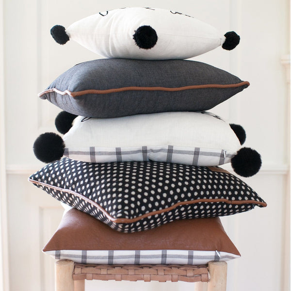 White pillow with black pom online poms